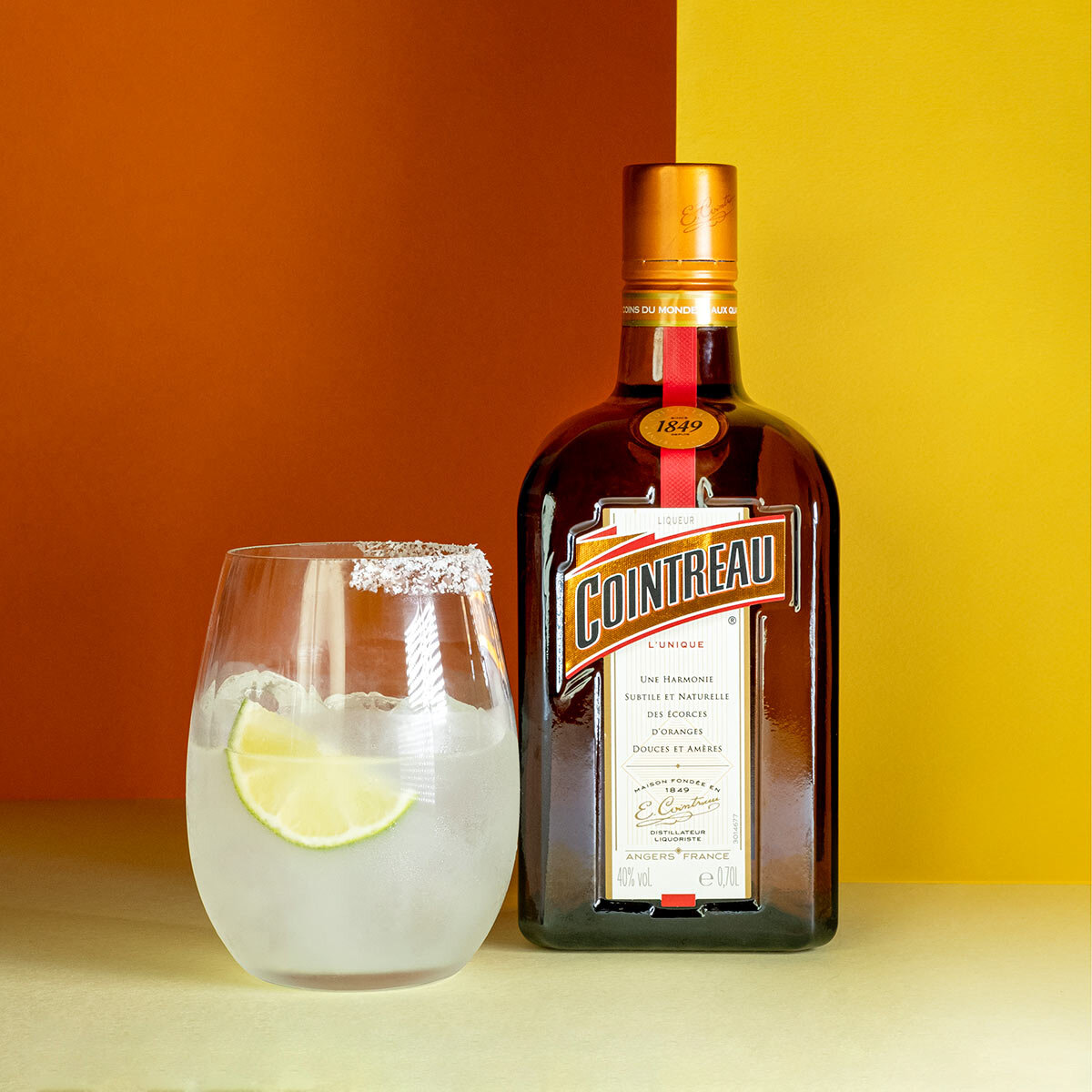 Lifestyleimage of bottle with cocktail infront of colourful background