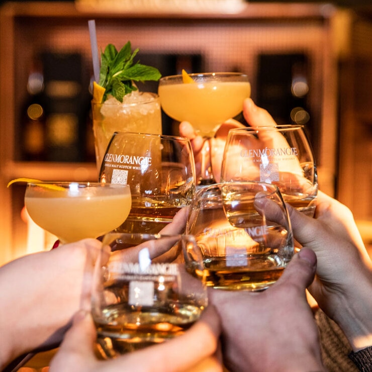 Lifestyle image of people sharing a toast with glasses of Glenmorangie Lifestyle image of people sharing a toast with glasses of Glenmorangie
